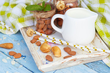 Almonds and jar with milk on the wooden tray