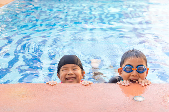 young boy and girl swimming in pool.