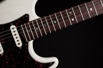 Obraz premium White electric guitar close-up of fingerboard frets and body