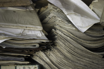 A closeup of old notebooks, folders and documents, stacked on top of each other. Scrap paper texture. Paper spreadsheets piled up. Used paper ready for recycling.