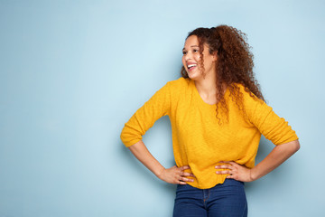 beautiful young woman laughing by blue background