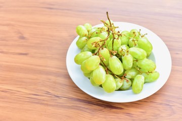 Bunch of Fresh Green Seedless Grapes Isolated on Wooden Table