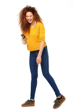 Full Body Happy Woman Looking At Cellphone Against Isolated White Background