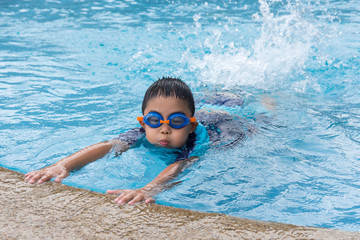 young boy swimming in pool.