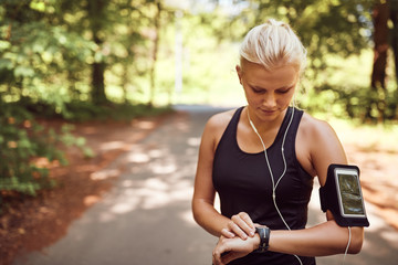 Fit young woman syncing her sports watch before a run