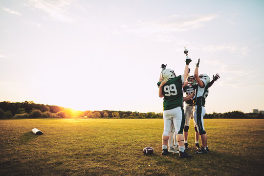 Football Team Celebrating With Their Championship Trophy On A Fi