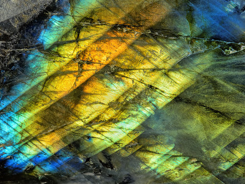 Amazing colorful texture of iridescence Labradorite Mineral gemstone background macro close-up. Beautiful reflective shiny Crystal