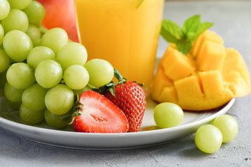 Mango juice, refreshing cocktail and fruits. Strawberries and grapes, healthy summer drink. Selective focus