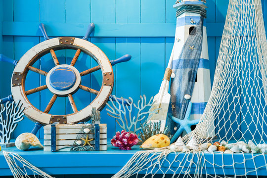 Blue summer concept which including ship's helm and hammock decoration with shell and marine creatures on blue table and wall