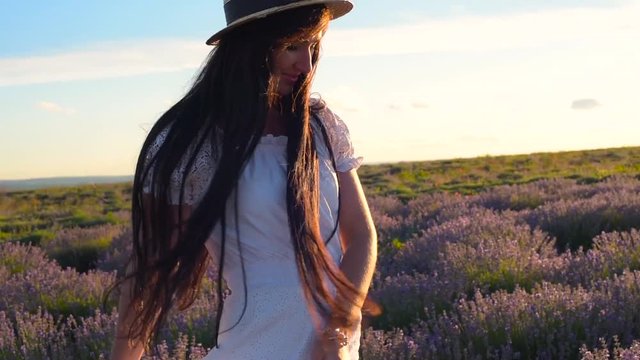 young pretty female having fun in lavender field during sunset