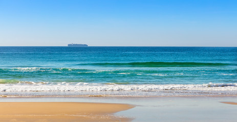 Praia e navio cargueiro de transporte de containers