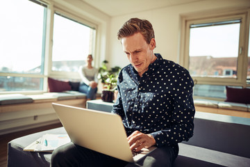 Young businessman working on a laptop in an office