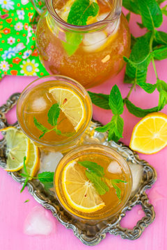 Sweet iced tea with mint, lemon and ice cubes