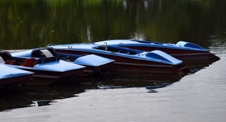 Obraz premium old and vintage blue pedal boats on a lake in bavaria, nostalgic pedal boats for rental and bathing