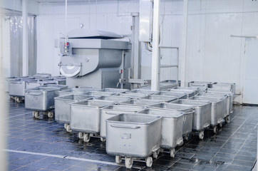 A trolley for transportation of meat. The steel capacity of the meat-packing plant. Equipment factory for the production of sausage. Background