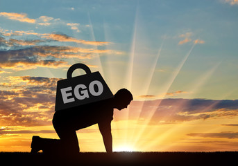The silhouette of an egotistic man who crawls, it's hard for him, on his back a heavy load - ego.
