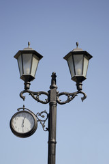 Fototapeta na wymiar pillar with lanterns and clocks