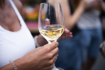 Hands holding a white wine glass