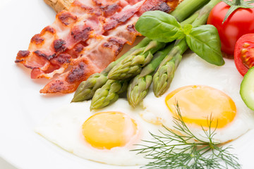 Fried eggs with bacon on the wooden table.