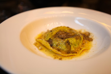 Simple yet beautiful dish of fresh Handmade Ravioli with Ricotta, Spinach and Parmesan, White Truffle and Brown Butter by a professional Starred Chef. Selective Focus.