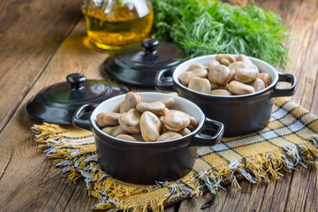 Broad beans served in black bowls.