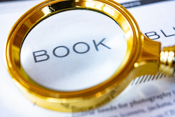 Focusing in reading book with magnifying glass