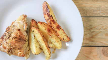Fried potatoes with chicken with golden crust on a white plate