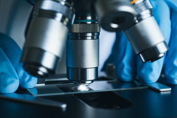 Scientist hands with microscope close-up shot in the laboratory