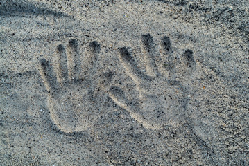 Hand print on sand of beach