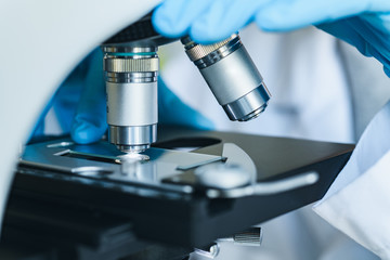 Scientist hands with microscope close-up shot in the laboratory