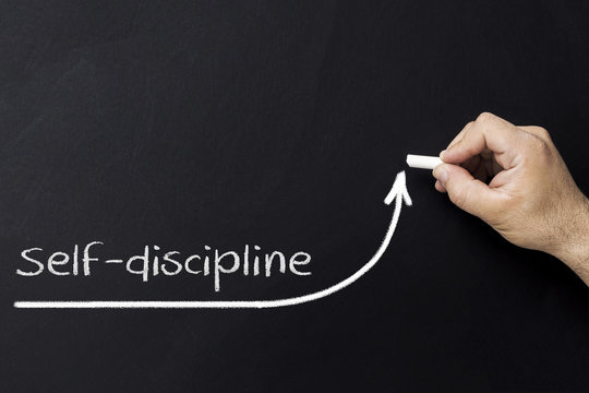 Self discipline concept. Hand with chalk drawing rising arrow. Discipline and self motivation.