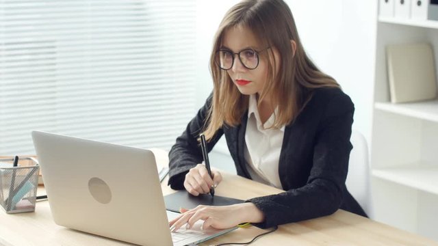 Woman designer working in office with graphic tablet