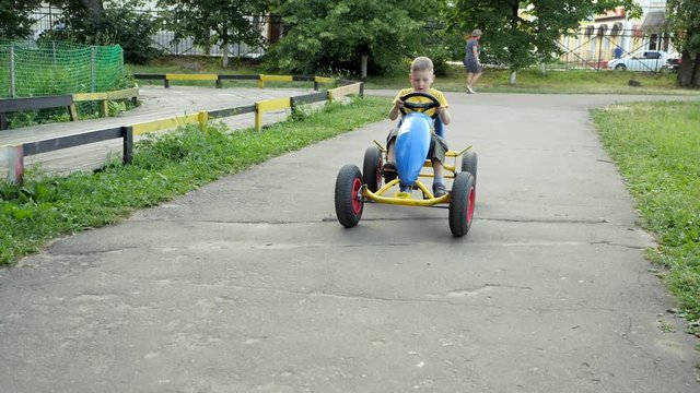Child rides on cycle mobile. child is driving a car. Slow motion