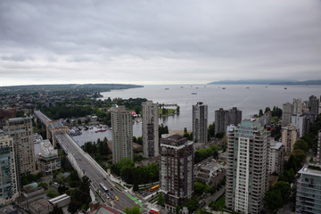 Aerial view of Downtown City Buildings overlooking the ocean during a cloudy overcast day. Taken in Vancouver, BC, Canada.