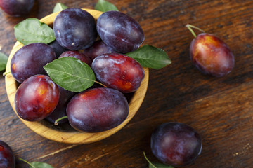 ripe plums on a wooden background