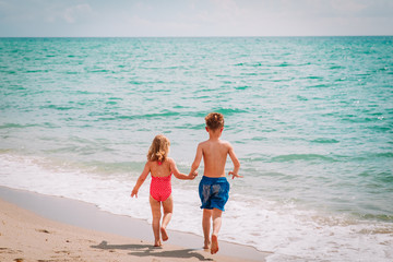 Naklejka premium little boy and girl run play at beach