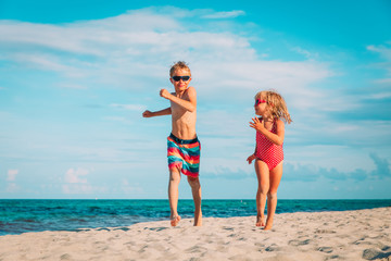 Fototapeta premium little boy and girl running at beach