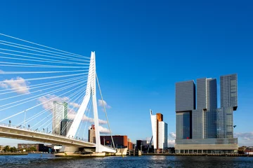 Papier Peint photo autocollant Rotterdam Paysage urbain de la ville néerlandaise de Rotterdam avec des immeubles de grande hauteur dans le quartier financier et la zone portuaire avec le pont Erasmus vu de l& 39 eau contre un ciel bleu avec des nuages duveteux