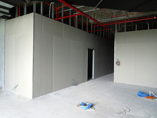 Drywall installation work in progress by construction workers at the construction site. It is the...