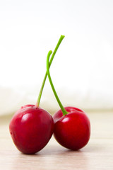 two Cherries Close-up. Cherry on wood and white background. - healthy eating and food concept