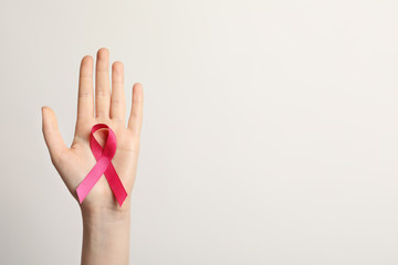 Woman holding pink ribbon on white background, top view. Cancer awareness