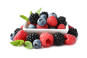 Bowl with raspberries, blackberries and blueberries on white background