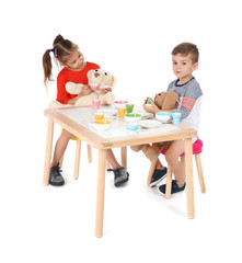 Little children playing tea party with toys on white background. Indoor entertainment