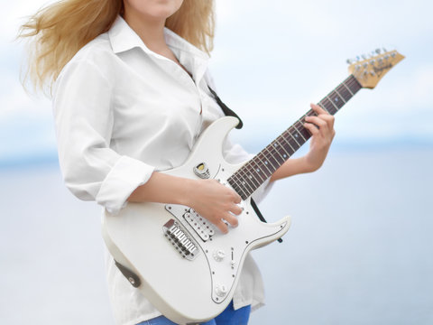 Girl holding a electric guitar.