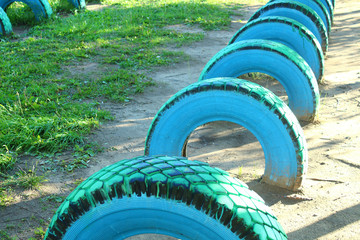 Automobile wheels dug into the ground. Sports ground in the school stadium. Playground. Close-up....