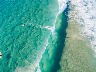 An aerial view of surfer riding a wave waiting at the beach on the Gold Coast in Queensland Australia
