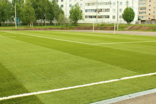Green artificial football field. The school stadium. Background.