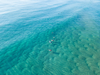An aerial view of surfers waiting for a wave at the beach on the Gold Coast in Queensland Australia