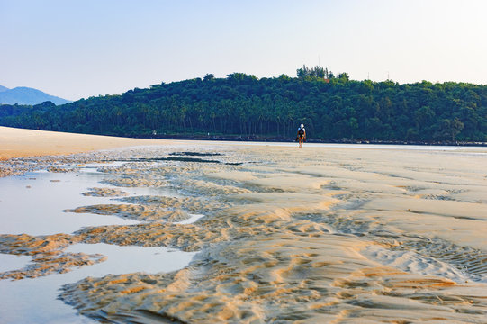 Tropical beach during low tide at sunset, Mobor Beach, South Goa, India. Seaside with sand dunes