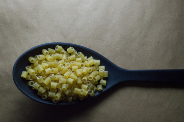 Colher de plástico para preparo de refeição na cor preta isolada com macarrão para sopa em...